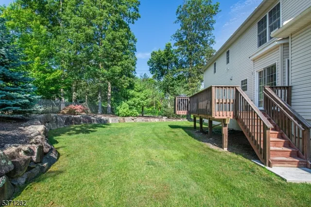 a view of backyard with deck and green space