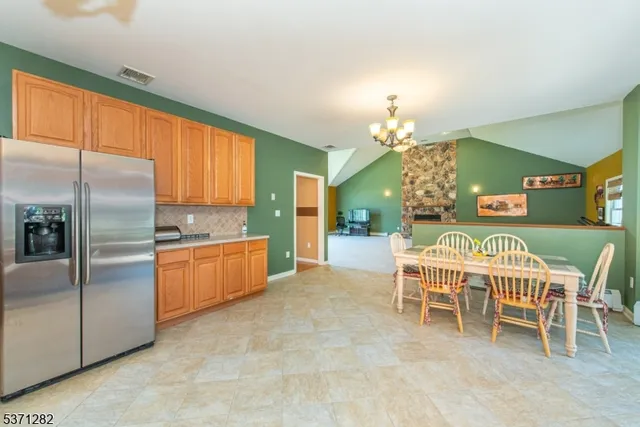 a dining room with a chandelier furniture and kitchen view