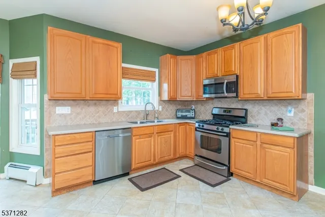 a kitchen with stainless steel appliances granite countertop a sink a stove a microwave and cabinets