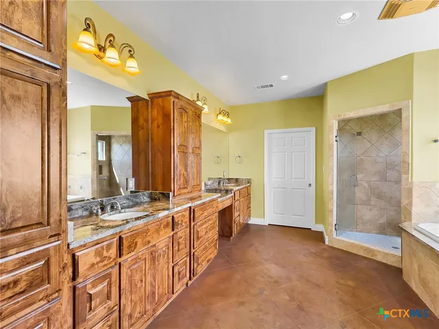 a bathroom with a double vanity sink a mirror and a shower