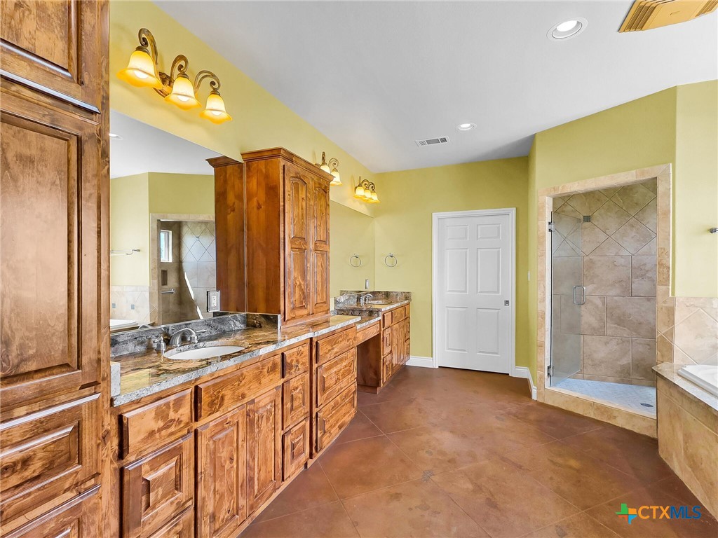 301 County Road 253 Bertram, TX 78605 - Photo 11 of 28 a bathroom with a double vanity sink a mirror and a shower