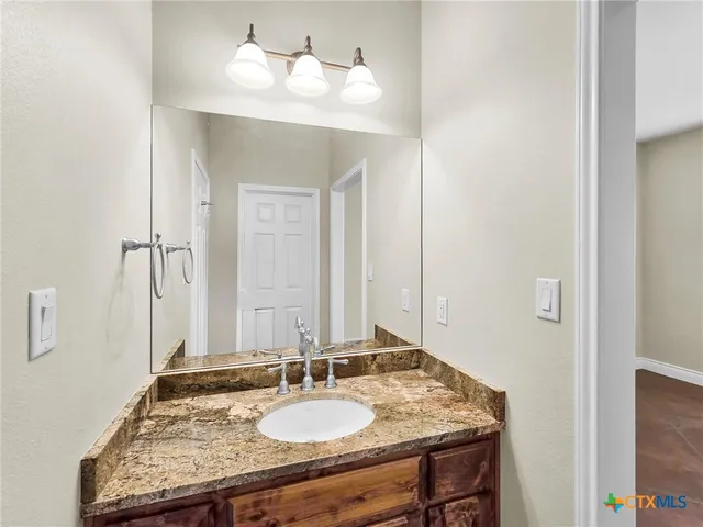 a bathroom with a granite countertop sink and a mirror