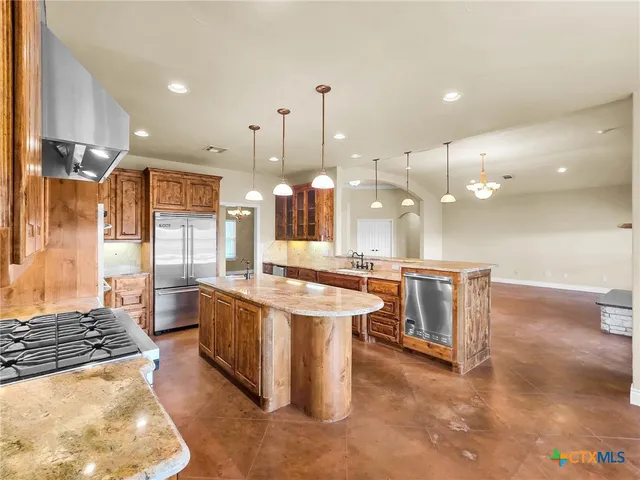 a large kitchen with a large counter top space appliances and a sink