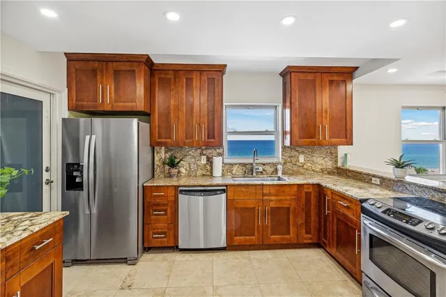 a kitchen with stainless steel appliances granite countertop a stove a refrigerator and a sink