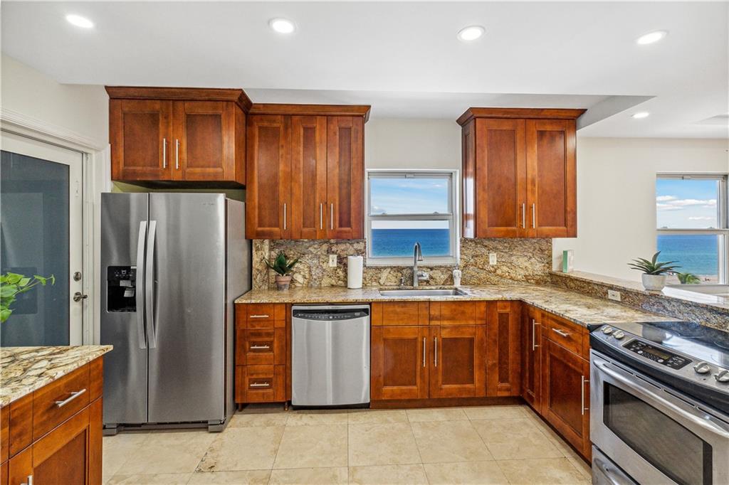 320 South Surf Road, Unit 601 Hollywood, FL 33019 - Photo 6 of 19 a kitchen with stainless steel appliances granite countertop a stove a refrigerator and a sink