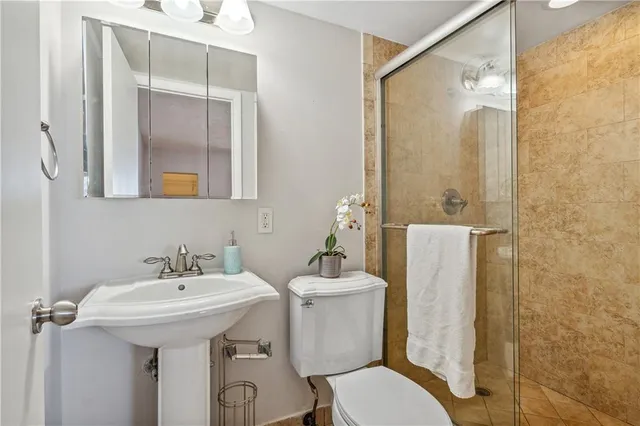 a bathroom with a sink mirror toilet and shower