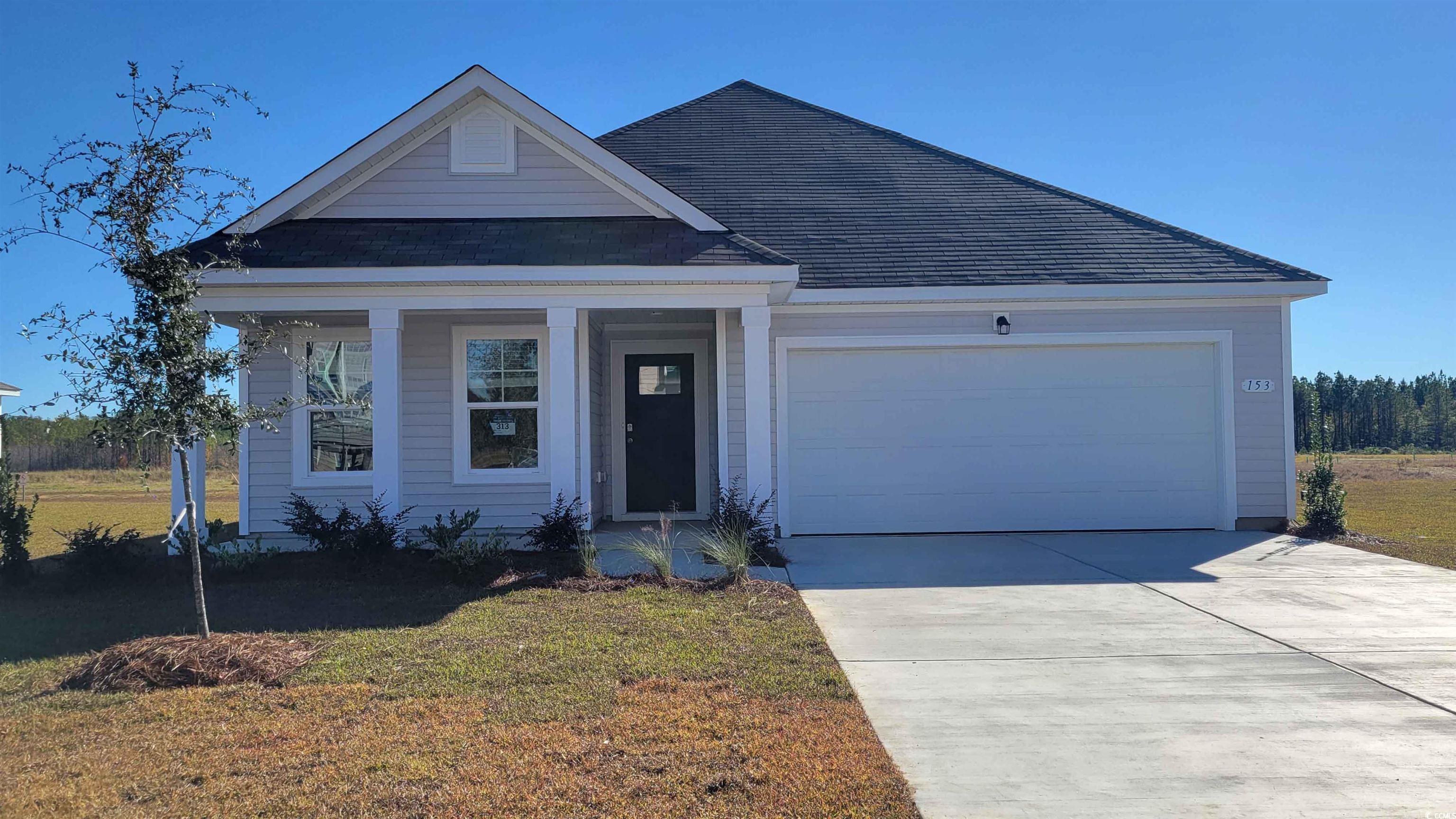 147 Cottage Red Court Conway, SC 29527 - Photo 1 of 21 View of front facade with a porch, an attached garage, concrete driveway, a front yard, and roof with shingles