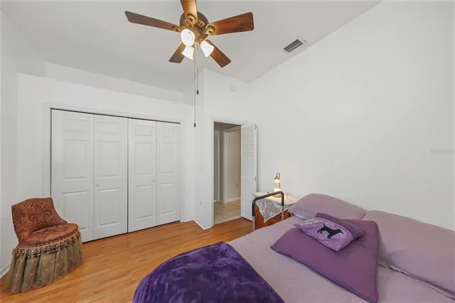 a bedroom with a bed a chair and a dresser next to a window