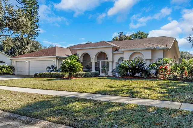 a white house with a big yard and a large tree