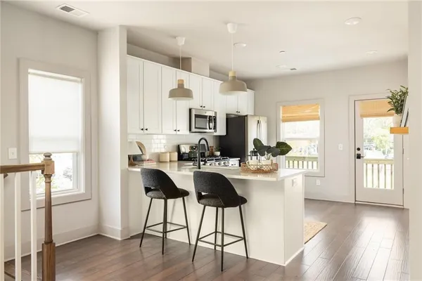 a kitchen with a table chairs refrigerator and cabinets