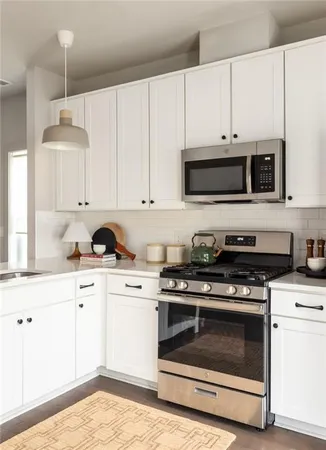 a kitchen with cabinets stainless steel appliances and wooden floor