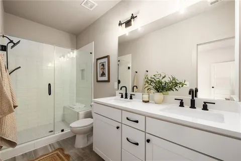 a bathroom with a sink a toilet and shower