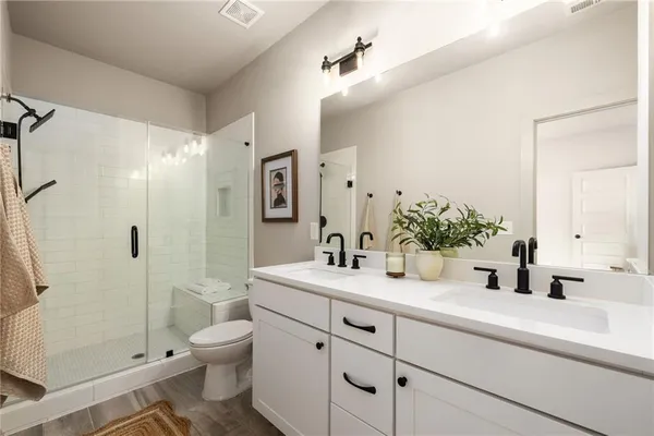 a bathroom with a sink a toilet and shower