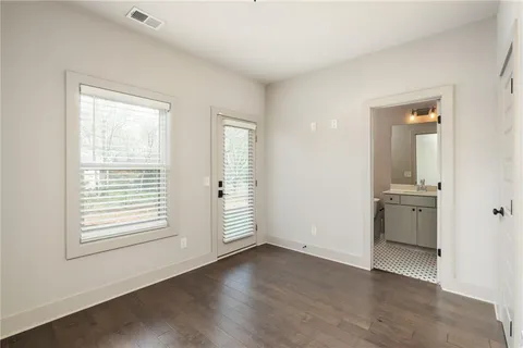 a view of an empty room with a window and wooden floor