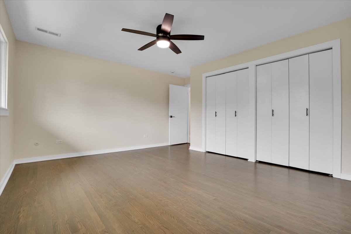 7330 Ogden Avenue, Unit 3 Riverside, IL 60546 - Photo 21 of 37 an empty room with a ceiling fan and wooden floor