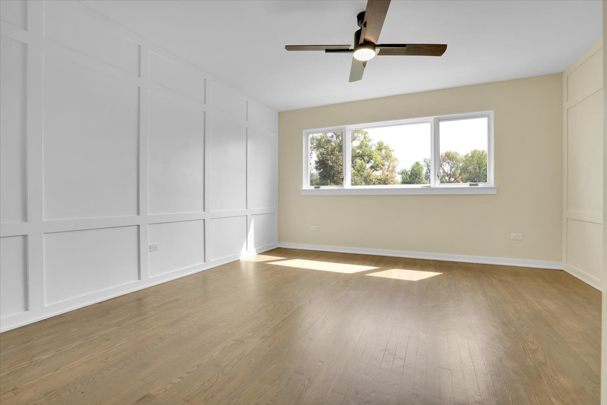 7330 Ogden Avenue, Unit 3 Riverside, IL 60546 - Photo 23 of 37 an empty room with wooden floor chandelier fan and windows