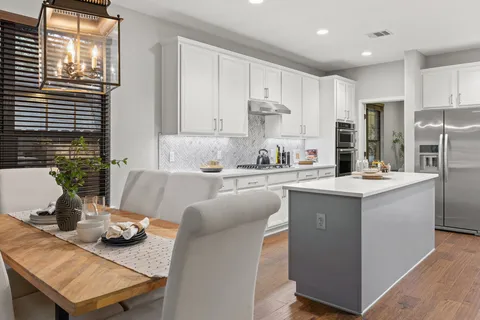 a kitchen with stainless steel appliances kitchen island granite countertop a sink and a refrigerator