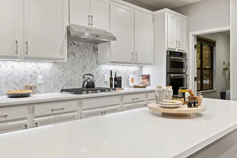 a kitchen with granite countertop white cabinets and white appliances