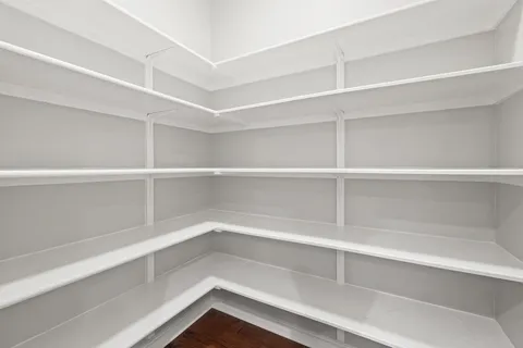 a view of walk in closet with empty racks