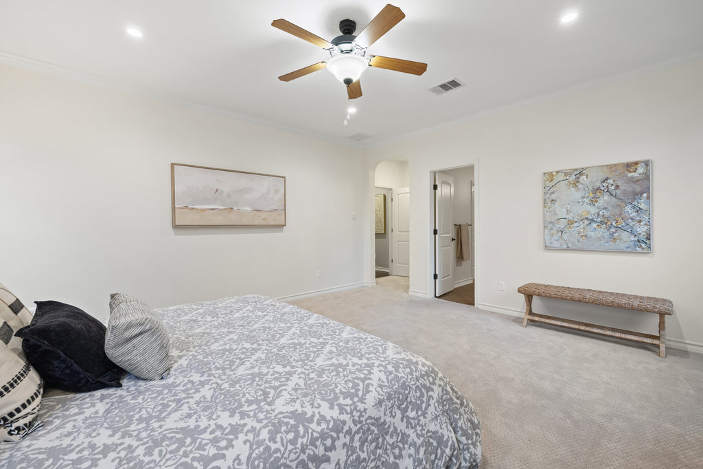 11217 Bastogne Loop Austin, TX 78739 - Photo 19 of 40 a bedroom with a bed and a chandelier