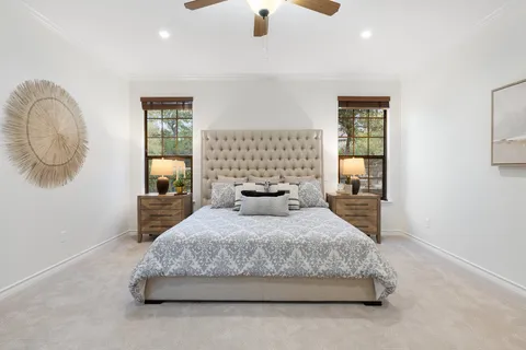 a bedroom with a large bed and a chandelier