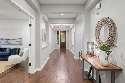 a view of a hallway with furniture and wooden floor