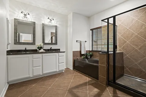 a bathroom with a granite countertop sink a mirror and shower