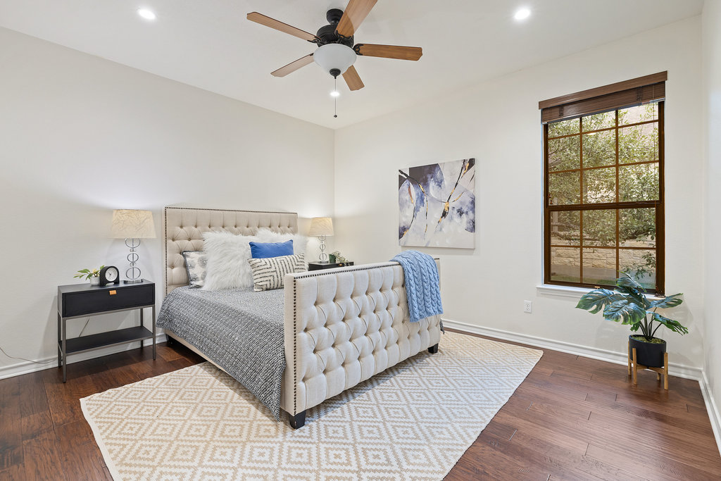 11217 Bastogne Loop Austin, TX 78739 - Photo 26 of 40 a bedroom with a large bed and a chandelier