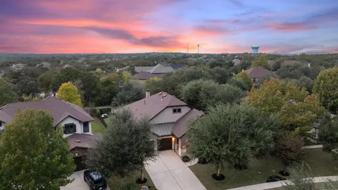 an aerial view of residential houses with outdoor space and trees