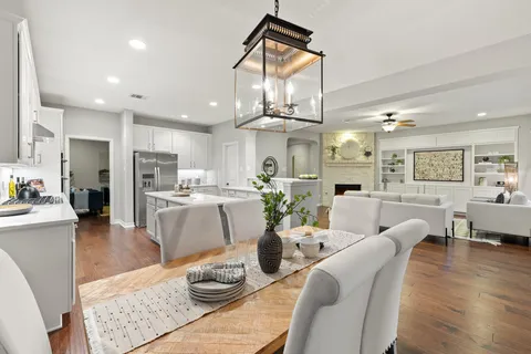 a living room with furniture kitchen view and a chandelier