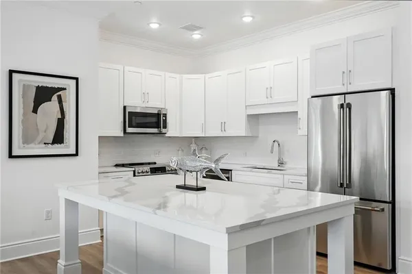 a kitchen with stainless steel appliances granite countertop a sink a refrigerator and a stove