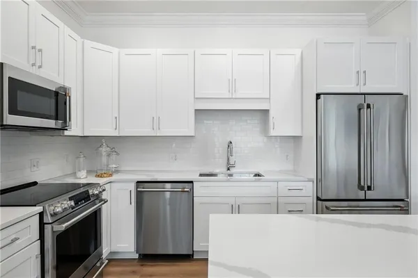 a kitchen with stainless steel appliances granite countertop a sink stove and refrigerator