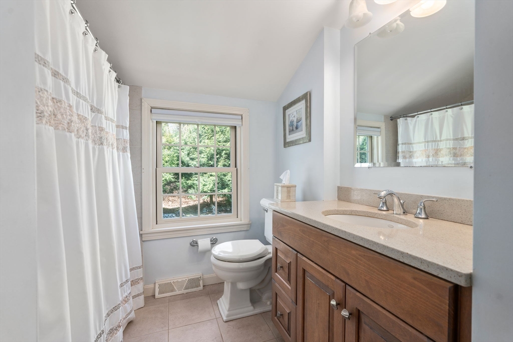40 Amble Road Chelmsford, MA 01824 - Photo 19 of 26 a bathroom with a granite countertop sink toilet a large mirror and a window