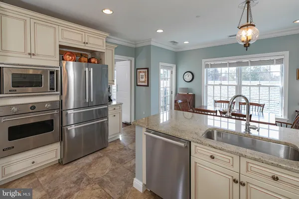 a kitchen with stainless steel appliances granite countertop a refrigerator and a sink