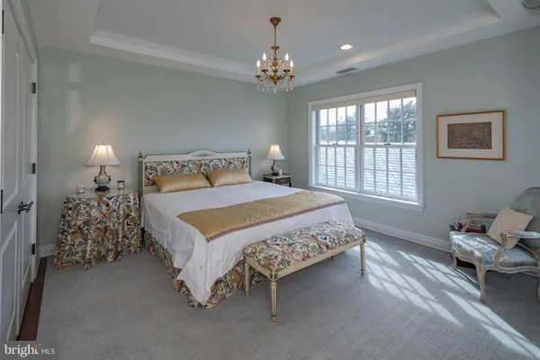 a bedroom with a bed and a chandelier