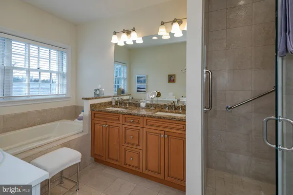 a bathroom with a granite countertop sink a toilet and shower