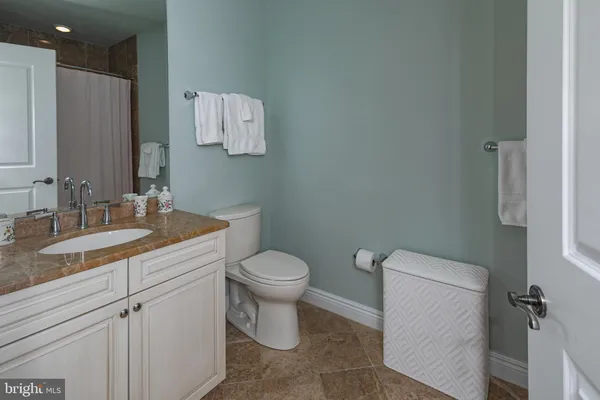 a bathroom with a granite countertop sink a toilet and a mirror