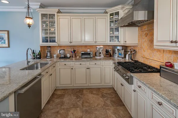 a kitchen with stainless steel appliances granite countertop a sink stove and cabinets