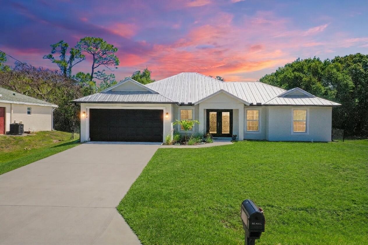 a front view of a house with a yard and a garage