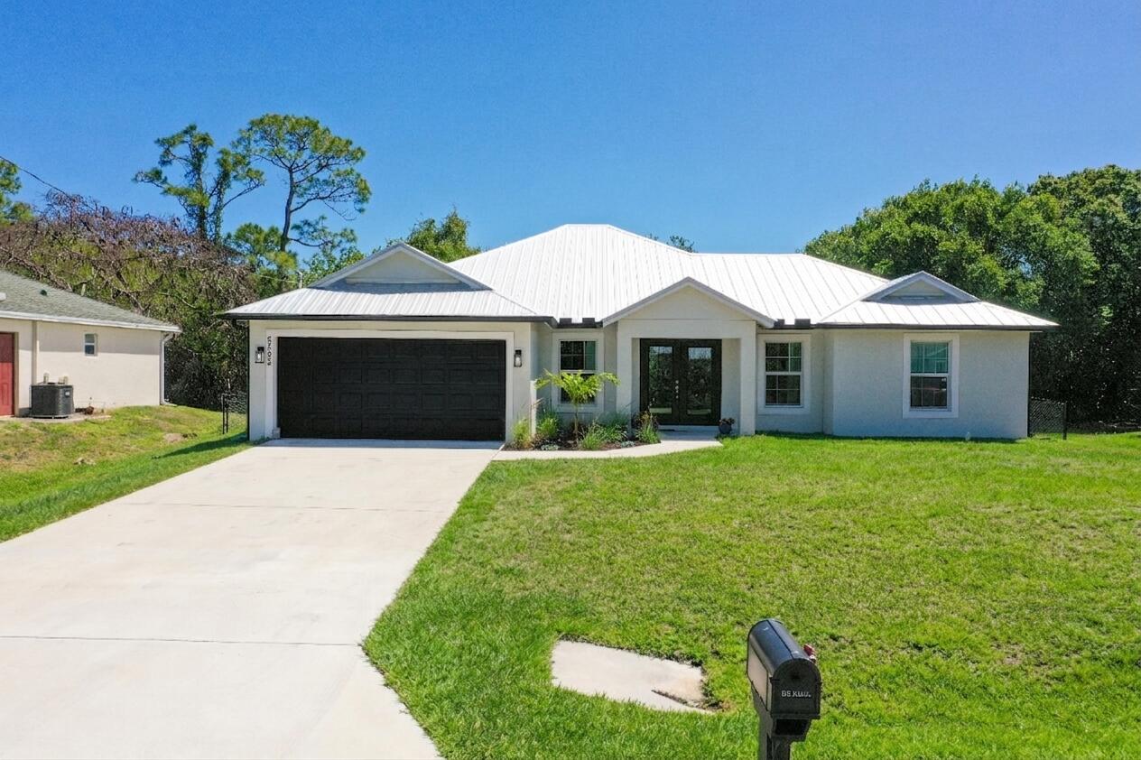 5302 Seagrape Drive Fort Pierce, FL 34982 - Photo 2 of 35 a front view of a house with a garden and yard