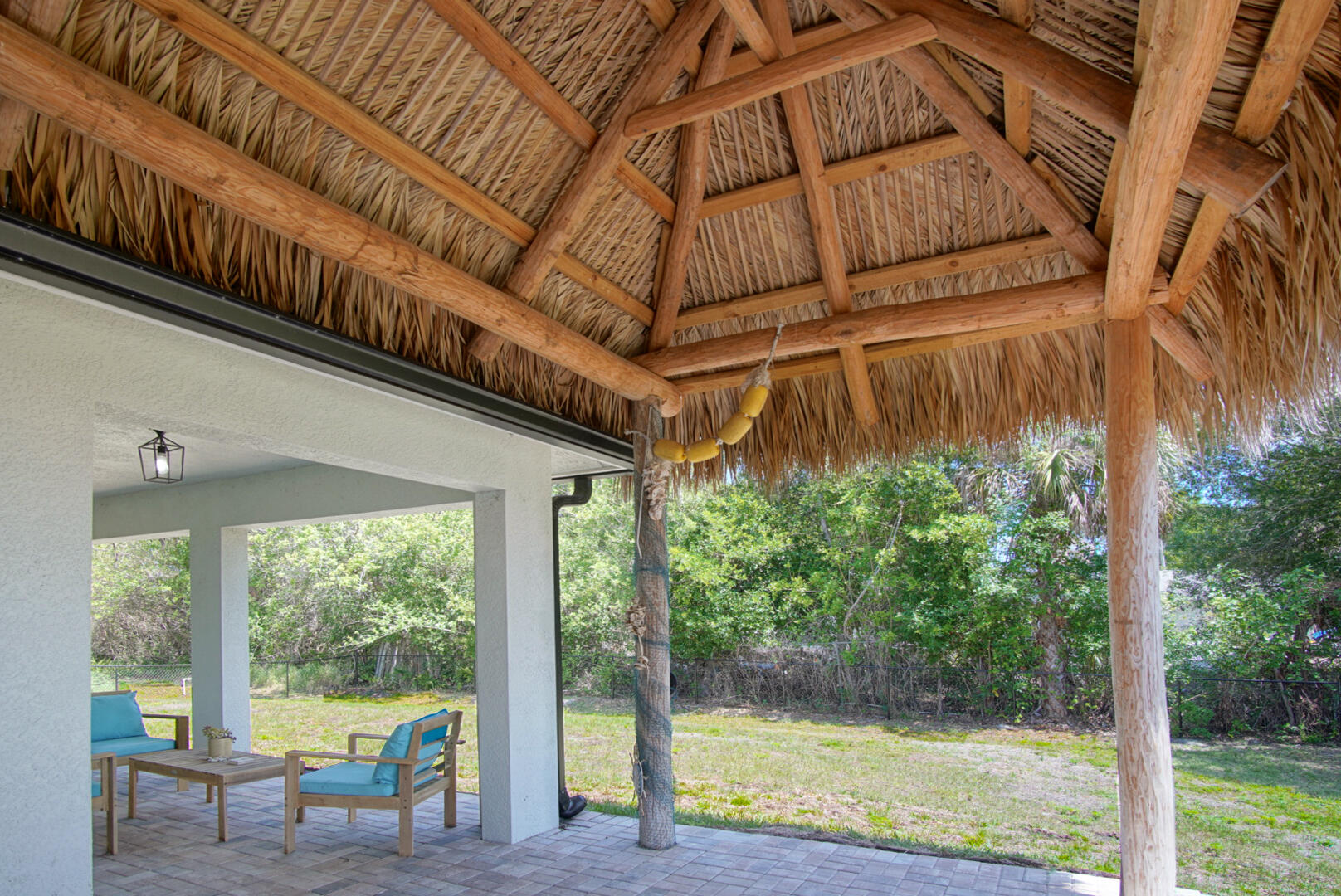 5302 Seagrape Drive Fort Pierce, FL 34982 - Photo 27 of 35 a view of a patio with table and chairs potted plants with wooden floor and fence