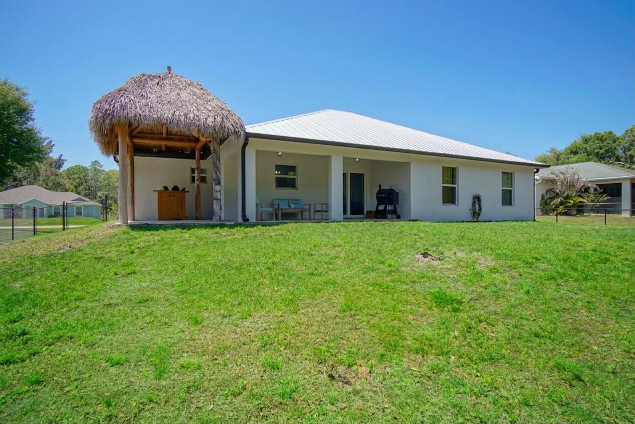 5302 Seagrape Drive Fort Pierce, FL 34982 - Photo 28 of 35 a view of a house with a big yard and large trees