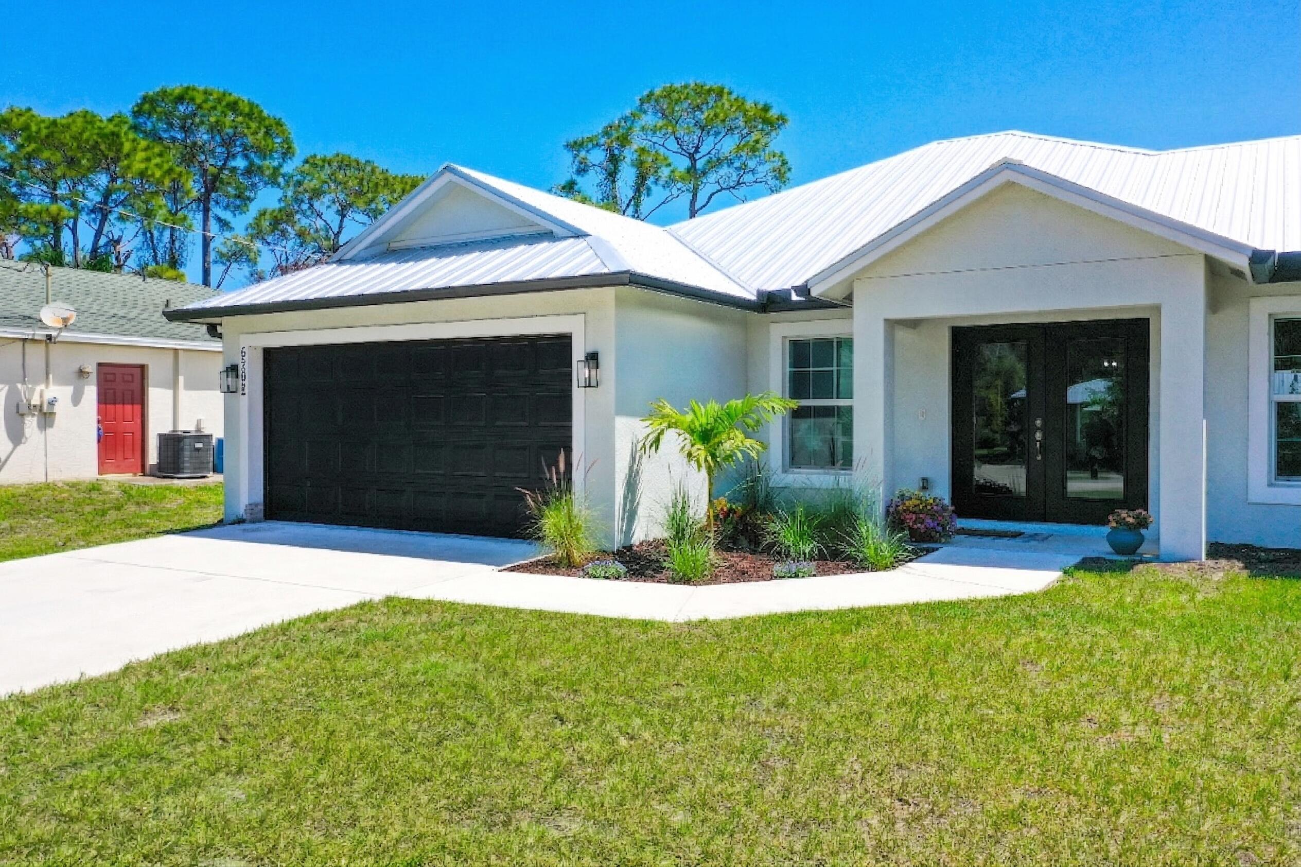 5302 Seagrape Drive Fort Pierce, FL 34982 - Photo 3 of 35 a front view of a house with a yard and garage