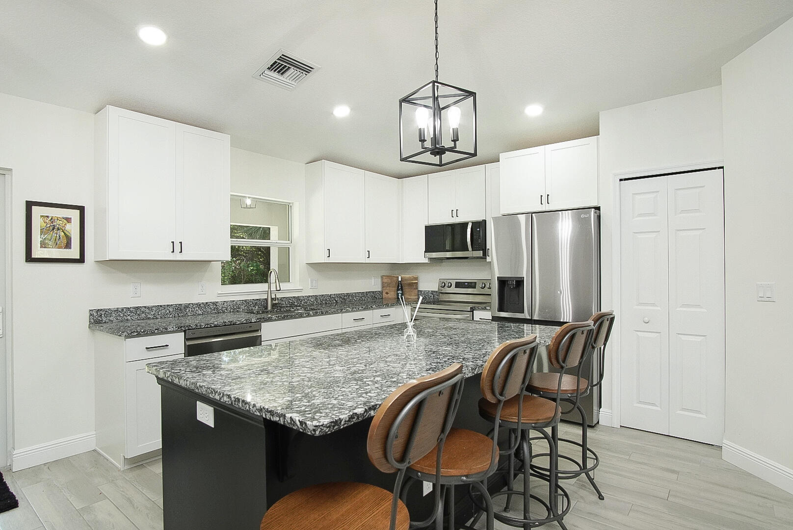 5302 Seagrape Drive Fort Pierce, FL 34982 - Photo 6 of 35 a kitchen with stainless steel appliances granite countertop a kitchen island hardwood floor and wooden floors