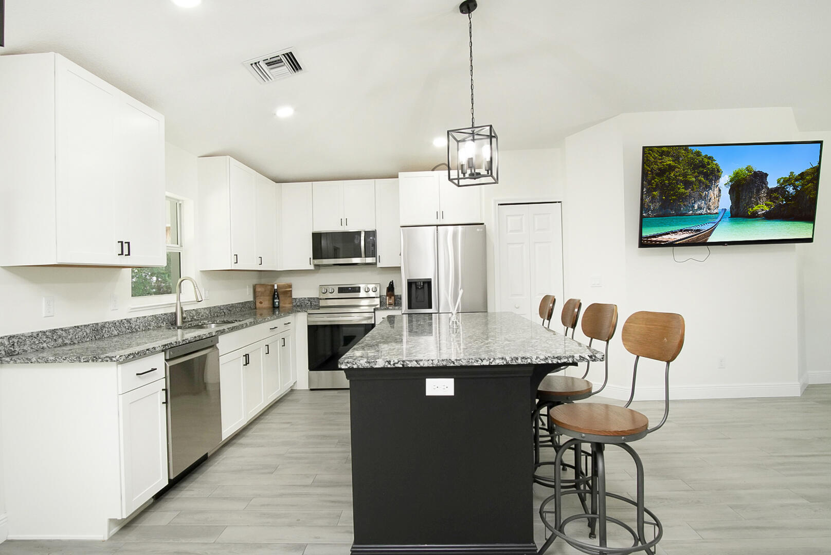 5302 Seagrape Drive Fort Pierce, FL 34982 - Photo 8 of 35 a kitchen with stainless steel appliances granite countertop cabinets a sink dishwasher a stove and a refrigerator with wooden floor
