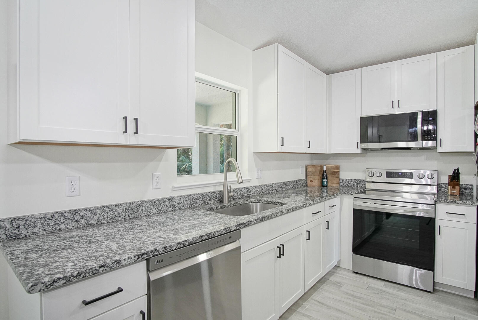 5302 Seagrape Drive Fort Pierce, FL 34982 - Photo 9 of 35 a kitchen with granite countertop a sink stainless steel appliances and white cabinets