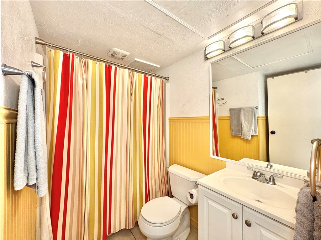 3938 Surfside, Unit 3233 Corpus Christi, TX 78402 - Photo 12 of 23 a bathroom with a sink a toilet and shower curtain