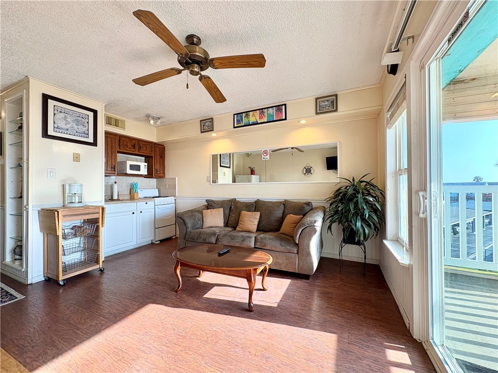 3938 Surfside, Unit 3233 Corpus Christi, TX 78402 - Photo 3 of 23 a living room with furniture and wooden floor