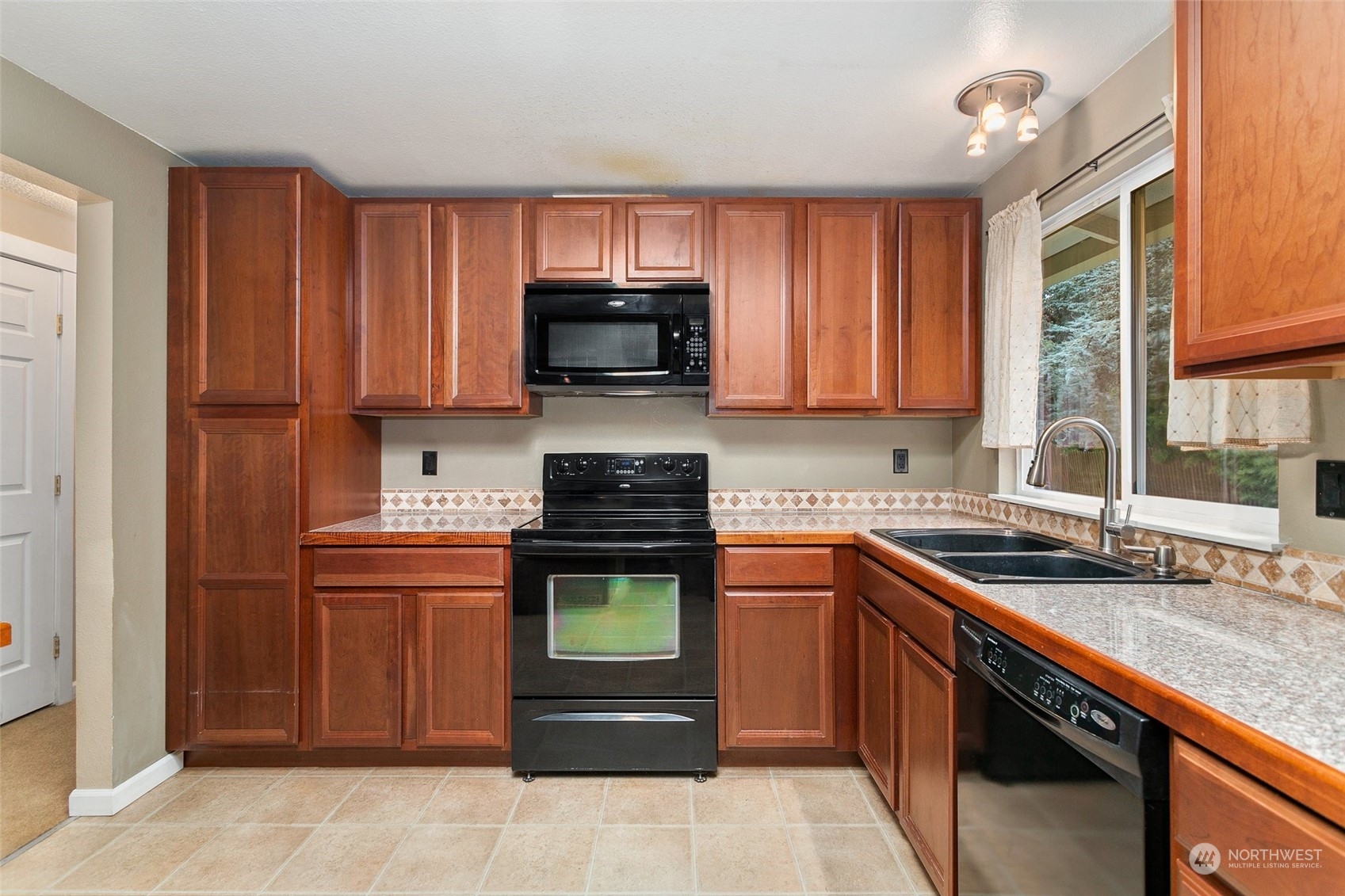 26007 36th Place South Kent, WA 98032 - Photo 12 of 37 a kitchen with stainless steel appliances granite countertop a sink stove microwave and refrigerator