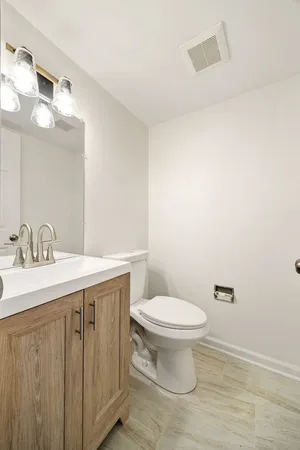a bathroom with a granite countertop sink a toilet and a mirror